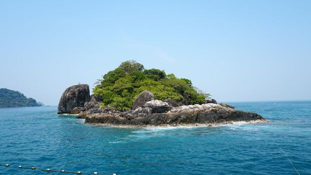 Travel by sea in Thailand by ship. View of the open ocean, green Islands and gray sky in smog. Green water with waves. Sailing between the Islands. Ship from different sides: stern, bow, rope, anchor.