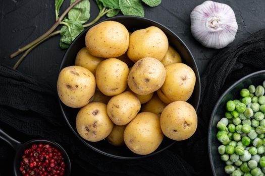 Fresh unpeeled, baby potatoes, top view, on black textured background