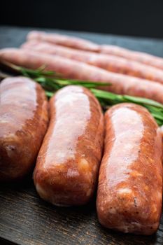 Traditional pork sausages, on black background.