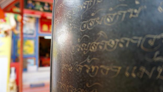 Chinese temple on Koh Chang island of Thailand. Bright colors of the temple, dragon and elephant sculptures. Flowers all around. The smoke from the sticks is coming. Hieroglyphs on the walls of bell.