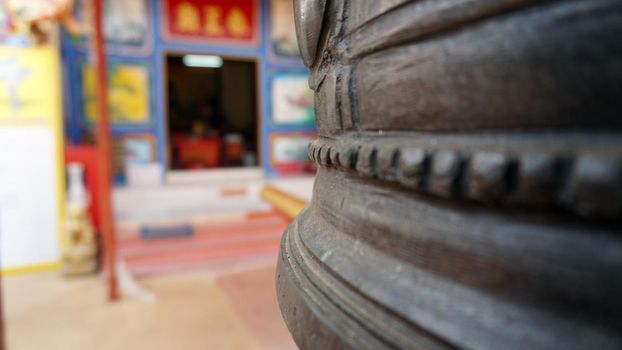 Chinese temple on Koh Chang island of Thailand. Bright colors of the temple, dragon and elephant sculptures. Flowers all around. The smoke from the sticks is coming. Hieroglyphs on the walls of bell.