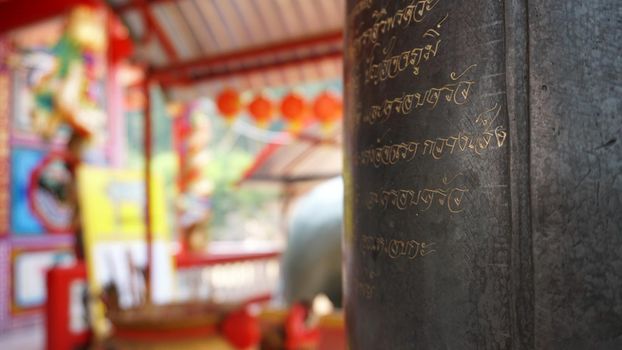 Chinese temple on Koh Chang island of Thailand. Bright colors of the temple, dragon and elephant sculptures. Flowers all around. The smoke from the sticks is coming. Hieroglyphs on the walls of bell.