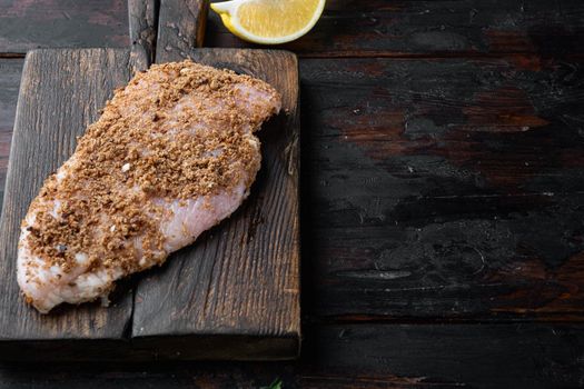 Raw crumbet chicken fillet with ingredient, on wooden table with copy space
