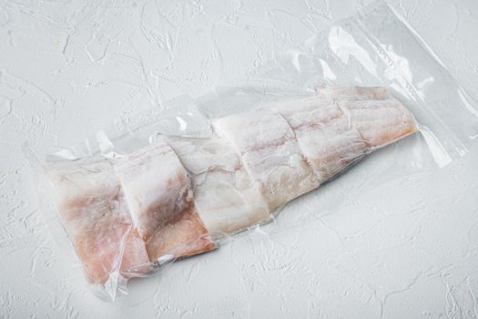 Raw haddock fish skinless plastic vacuum packaged, on white background
