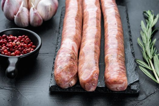 Homemade beef sausages, on black background.