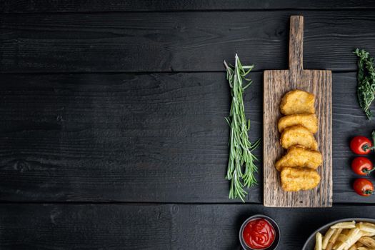 Chicken breast nuggets fried on black wooden table, flat lay, with copy space.