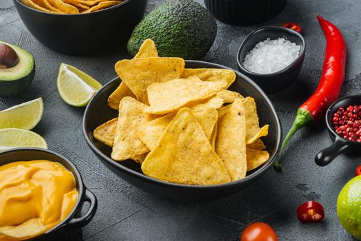 Mexican food concept. Nachos - yellow corn totopos chips with various sauce, on gray background