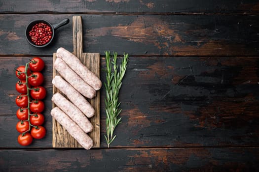 Chicken sausages, flat lay with space for text, on old dark wooden background.