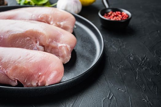 Crumbed uncooked chicken breasts ingredient, on black background with space for text