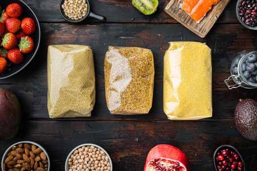 Couscous, bulgur and polenta packaged, flat lay on dark wooden background.