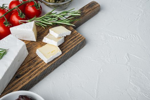 Antipasti platter with fresh cheese, bread and olive, on white background with copy space for text