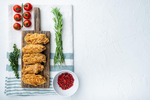 Breaded chicken wings cuts on white background, flat lay, with space for text.