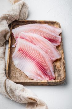 Raw tilapia fish fillet meat cuts, on white background