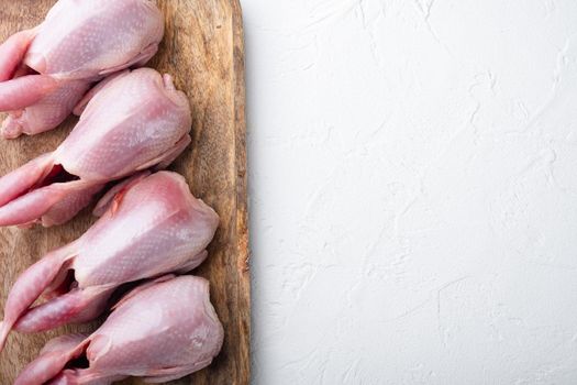 Fresh organic whole quail meat, flat lay, on white textured background with space for text