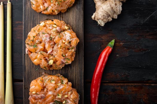 Raw quick asian salmon cutlet, on old wooden table, top view