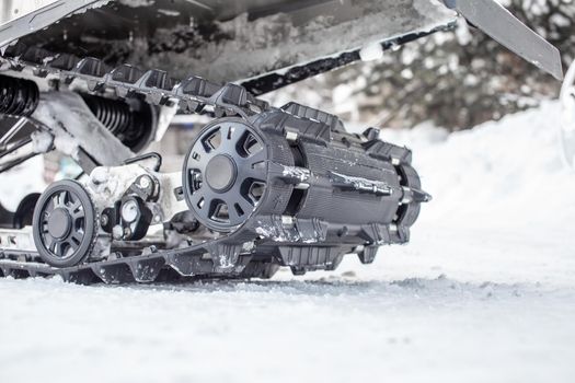 The back of the snowmobile in winter on the snow. Riding in the snow on a snowmobile. Rear suspension of a snowmobile