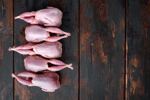 Fresh organic whole quail meat, flat lay, on dark wooden background with space for text