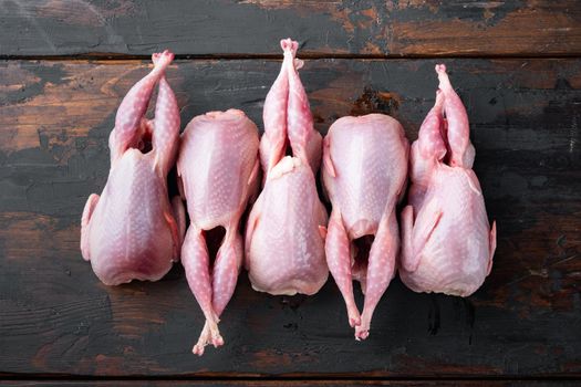 Fresh raw quail set, top view, on dark wooden background