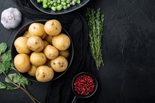 Raw baby potatoe, flat lay, on black textured background with space for text