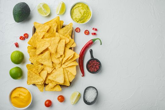 Nacho tortilla with cream sauce served with guacamole and cheese dip sauce, on white background, top view or flat lay