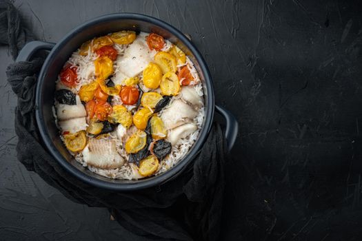 One pan fabulous fish, with basmati rice and cherry tomatoes, on black background, top view with copy space for text