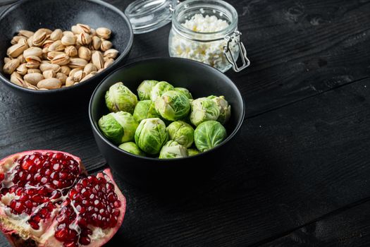 Brussels sprouts with pomegranate, cottage cheese and pistachios, on black wooden table