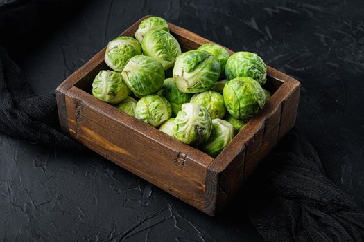 Raw brussels sprouts, on black textured background