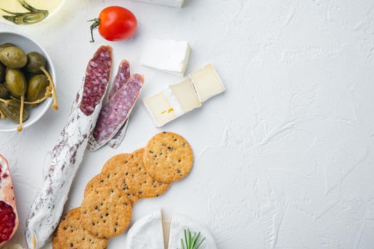 Appetizers table with differents antipasti set, on white background, top view with copy space for text