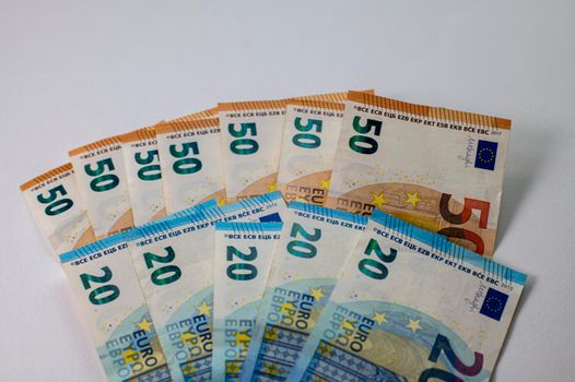 50 and 20 euro banknotes fanned out on a white background