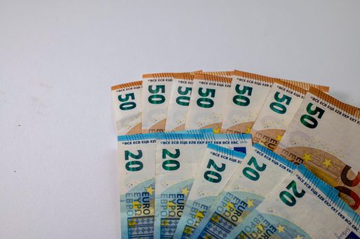50 and 20 euro banknotes fanned out on a white background