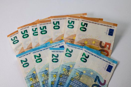50 and 20 euro banknotes fanned out on a white background