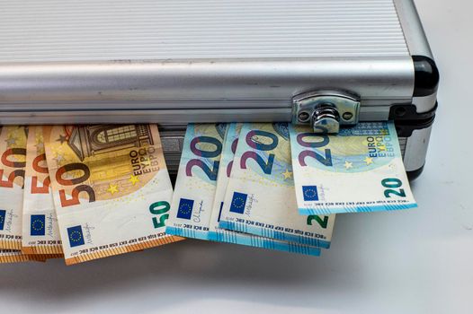 50 and 20 euro banknotes on aluminum briefcase on white background