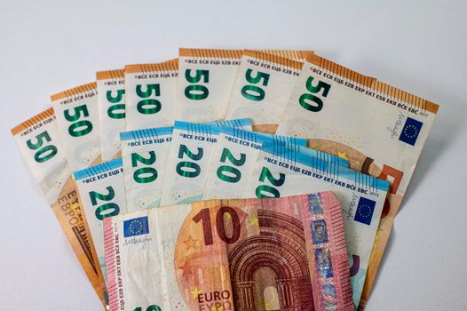 50e 20 and 10 euro banknotes fanned out on a white background