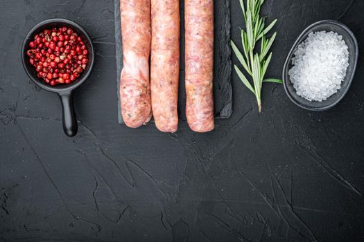 Traditional beef sausages, top view with space for text, on black background.
