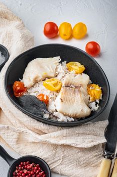 Tilapia fish with basmati rice and cherry tomatoes, in bowl, on white background