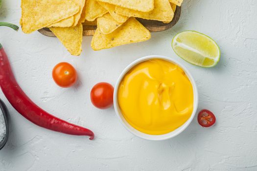 Bowl with cheese dip with nacho, on white background, top view or flat lay