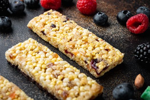 Homemade granola bars with mixed nuts, seeds and berries, on old dark table