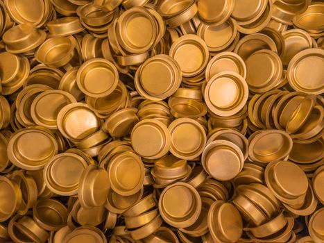 pile of stamped thin sheet brass hat-shaped semimanufatures, full frame industrial manufacturing background