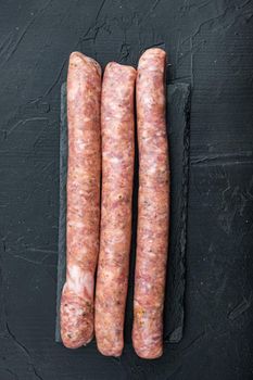 Homemade beef sausages, top view, on black background.
