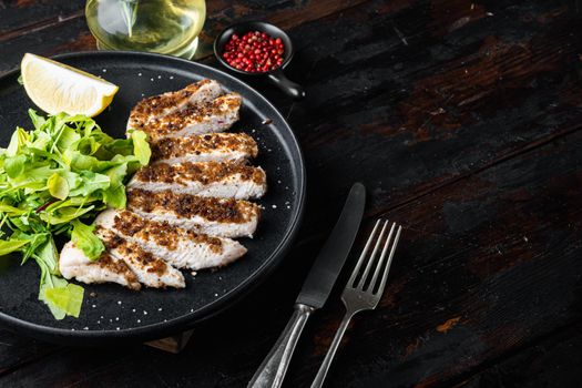 Crumbed, chicken breast fillet grilled, on wooden table with space for text