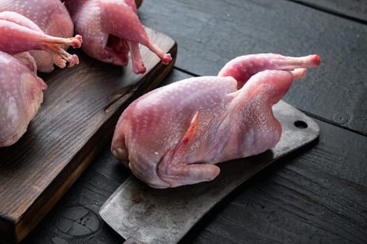 Raw uncooked quails set, on black wooden background