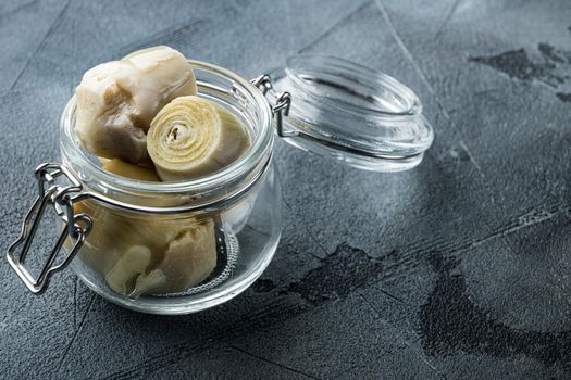 Artichoke hearts marinated with olive oil, on grey background