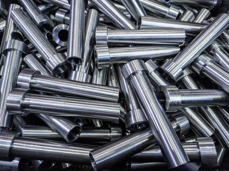 full frame abstract indistrial background of pile of shiny steel tubes after cnc turning operations