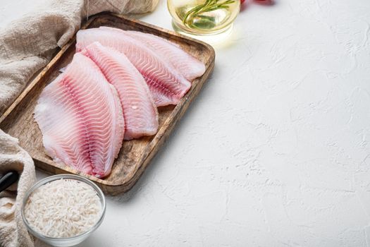 White fish fillet, with basmati rice and cherry tomatoes ingredients, on white background with copy space for text