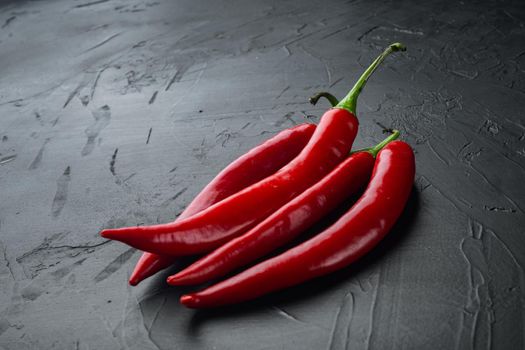 Whole red chili peppers set, on black background with copy space for text