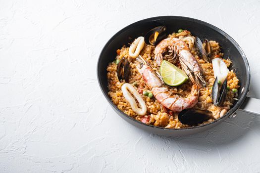 Paella with seafood and chicken on white background with space for text, food photo.