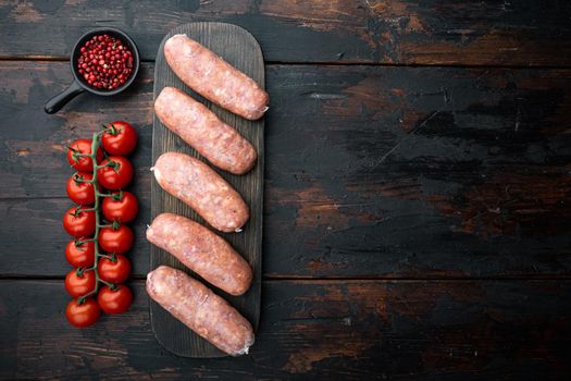 Raw organic pork sausages, top view with space for text, on old dark wooden background.