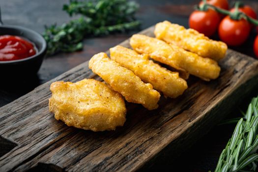 Nuggets breaded on old dark wooden table.