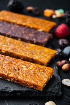 Fruit berry nut energy bars, healthy snack, on black background