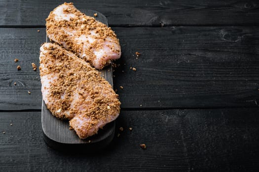 Crispy garlicky chicken raw ingredient, on black wooden background with copy space